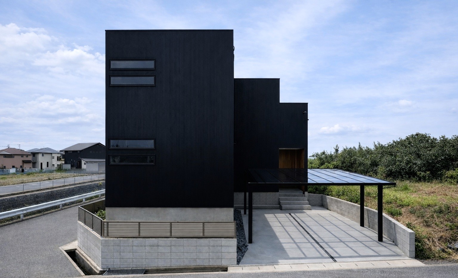 黒いガルバリウム外壁と木板張りを組み合わせた住宅外観