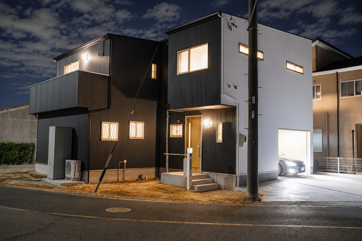 黒と白の外壁が浮かび上がる夜の外観